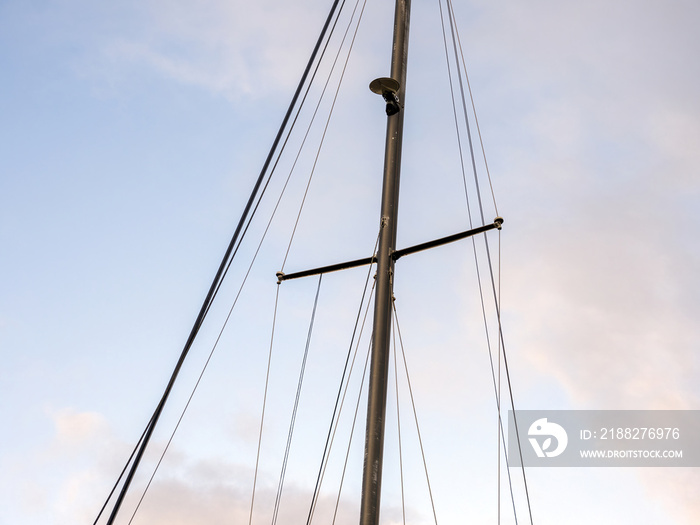 Yacht mast with ropes with sky in background