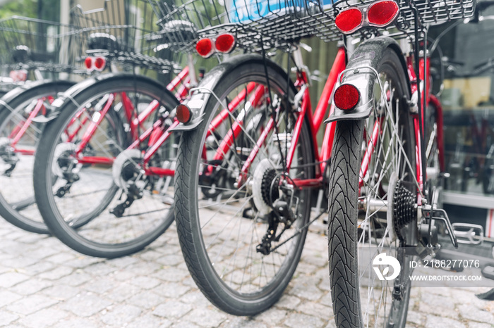 Closeup view many red city bikes parked in row at european city street rental parking sharing station or sale. Healthy ecology urban transportation. Sport environmental transport infrastructure