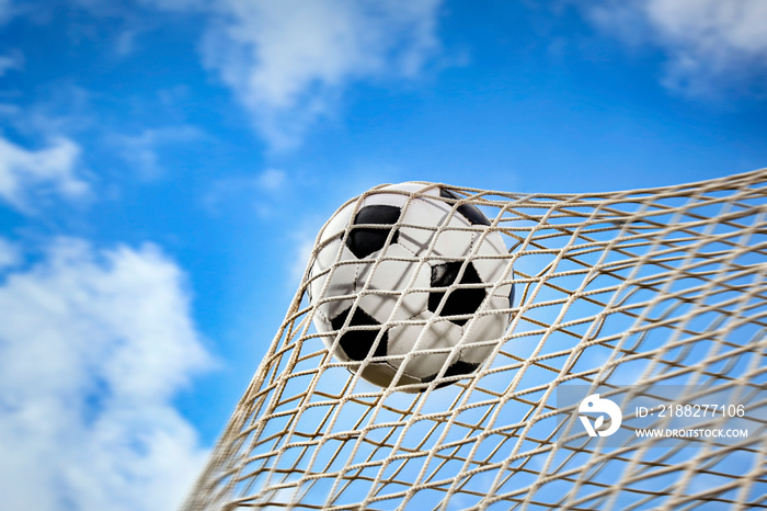 soccer ball in a net and a blue sky