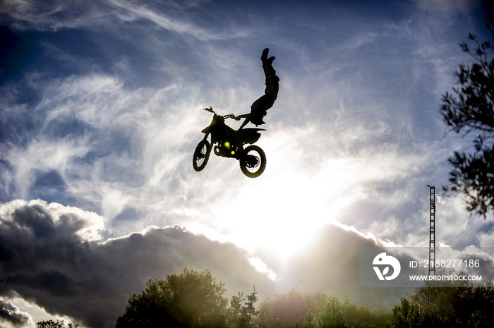 Motorcyclist jumping with motorcycle..