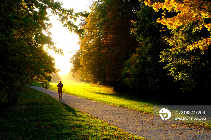 A man running in  the park with sun shining from the back.