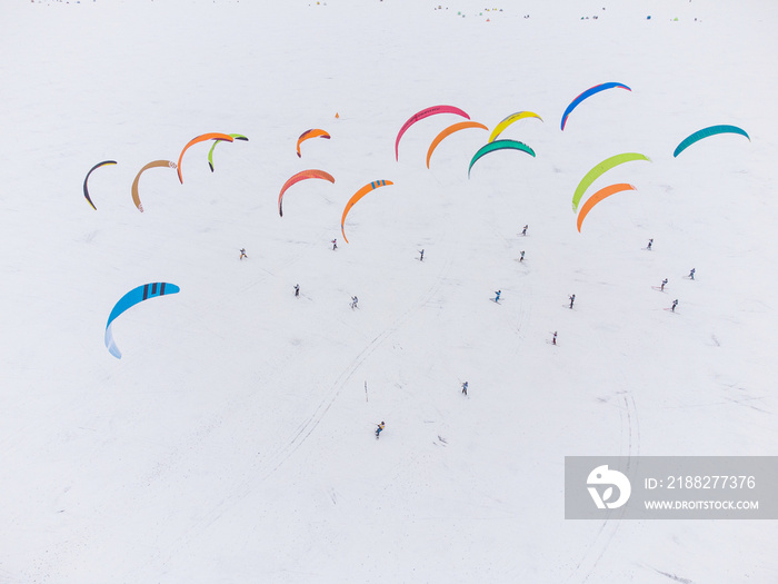 SnowKiting kitesurfing sport on the ice lake winter. Aerial drone view.