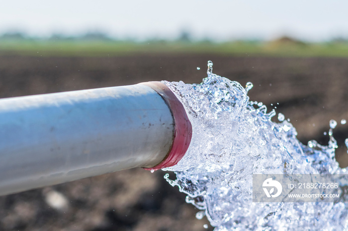 high pressure crystal bluish sweet water flushing out of an agriculture industrial tube waell in fields