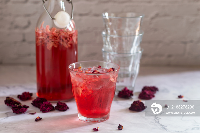 glass of rose Kombucha with iced on white table ,fermented tea drink, healthy beverage.