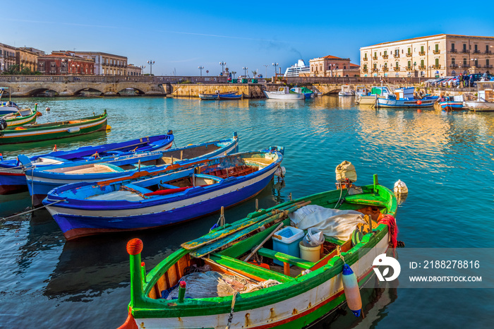 Colorful and bright close up fishing boats on water in the bay of the island Ortigia, Syracuse in Sicily, south Italy