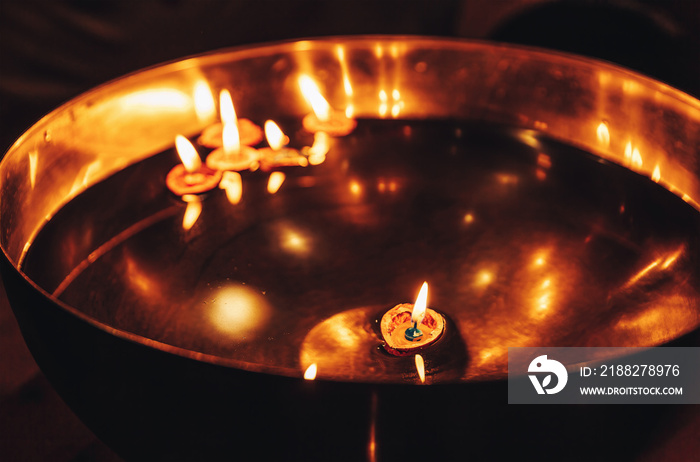 Candle in walnut shell placed in a bowl of water. Christmas tradition.