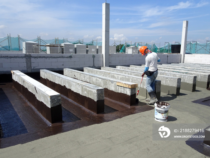 Waterproofing layer applied by construction workers on top of concrete slab. Waterproofing layer to prevent water from entering below of the concrete slab.