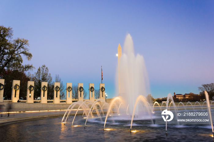 Night-time view from the National World War Two Memorial plaza including the illuminated Rainbow Pool & Washington Monument behind, National Mall, Washington DC