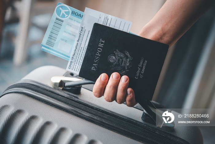 People holding passports and coronavirus vaccination card, map for travel with luggage for the trip. Covid-19 around the world