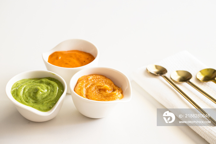 Three typical Canary Islands sauces, mojo picon, mojo verde  and almogrote  in ceramic bowl on modern restaurant table