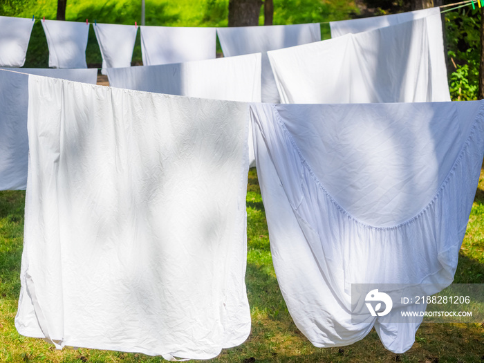 fresh white laundry hanging on a washing rope outdoor in a summer camp in a forest, close up photo