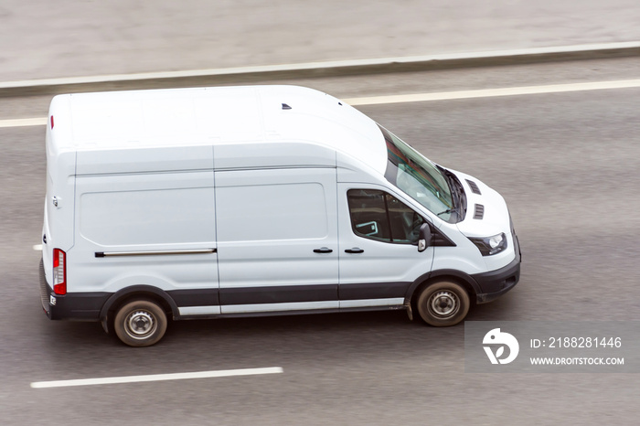 White minibus goes on the city highway street.