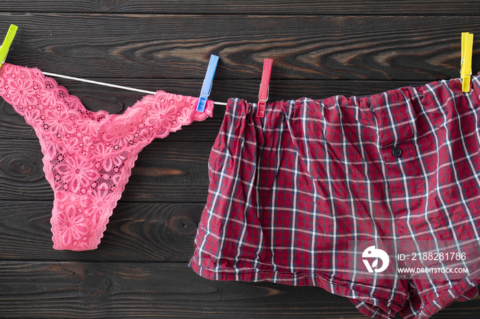 Pink panties and boxer briefs. Underwear on rope with clothespins. Red color as love symbol.