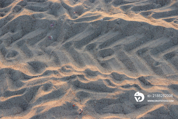 Abstract background beach sand with tire marks and sunlight reflection