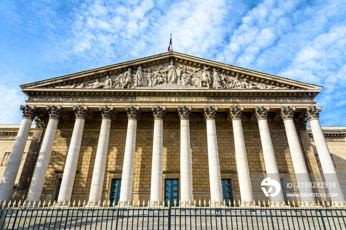 Low angle view of the neoclassical facade of the Palais Bourbon, with portico, colonnade and pediment, seat of the french National Assembly (Assemblée Nationale) in Paris, France.