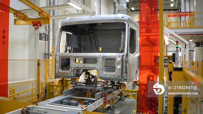 Truck body at factory. Scene. Frame of truck is moving on rails of factory. Modern equipment at truck manufacturing and assembly plant