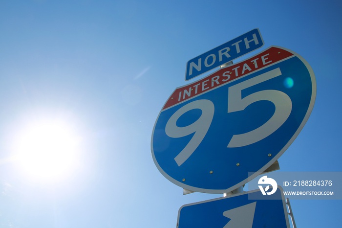 I-95 North Sign Backlit by Sun Against Clear Blue Sky