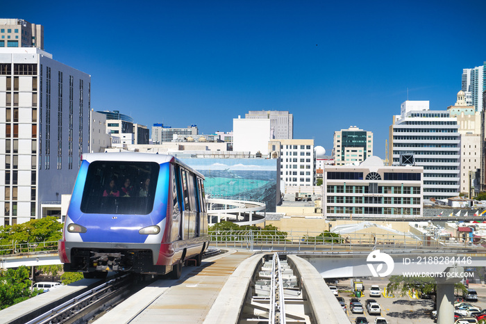 Downtown Miami Metrorail train speeding up among the city skyscrapers