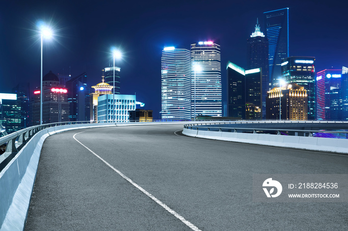 High speed corner overpass asphalt road with modern skyscraper , night scene .