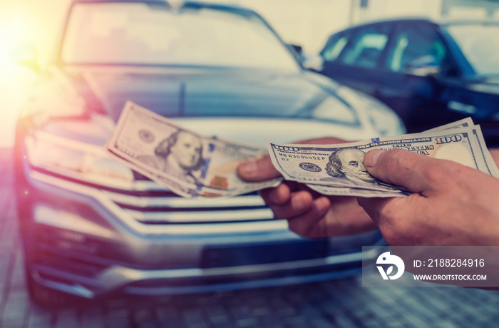 dealer make agreement to buy a new car, man holding dollar