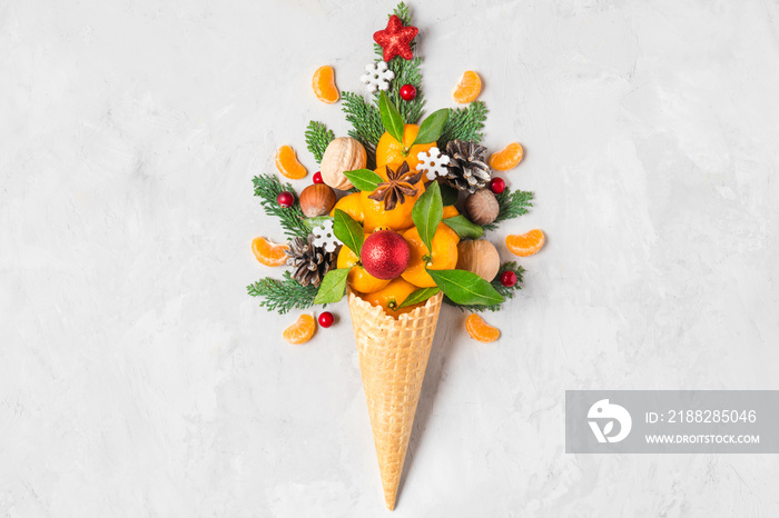 Christmas decorations in waffle ice cream cone with fir branches, tangerine fruits and decorations. top view. flat lay