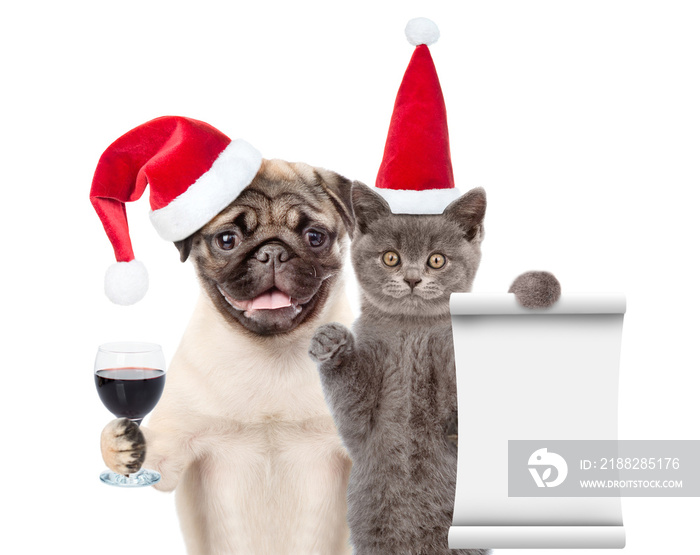 Funny cat holds empty list. Pug puppy holds glass of wine. Pets wearing red christmas hats. isolated on white background