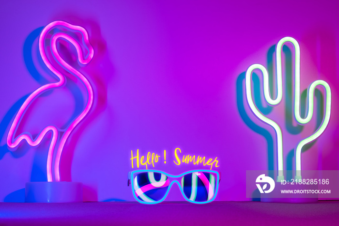 Hello summer with flamingo,cactus,sunglasses refection neon pink and blue and green light on table with copy space.Trendy vacation holiday background.