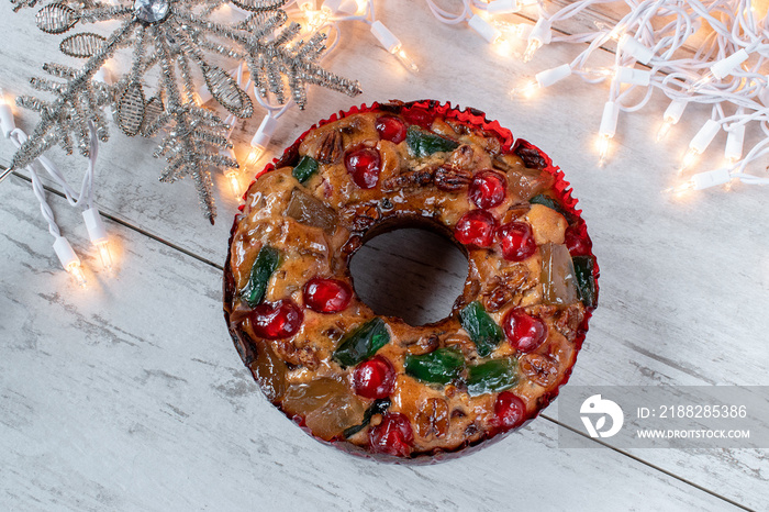 whole fruit cake with Christmas star and lights flat lay