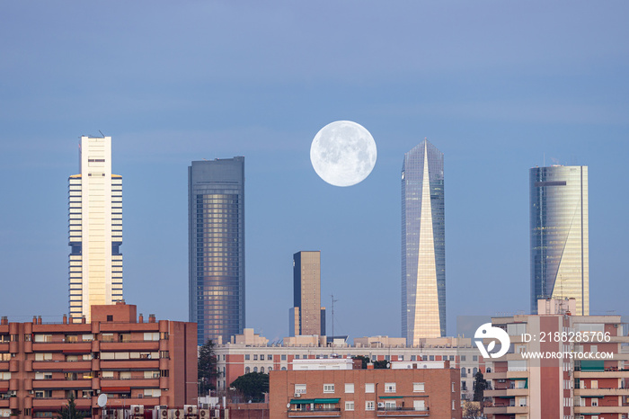 The moon over the four towers in the city of Madrid