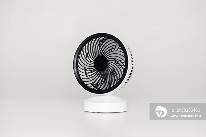 Petit ventilateur de bureau USB isolé sur un bureau blanc