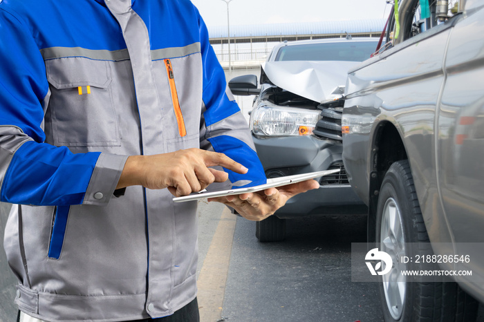 Insurance officer writing clipboard and examining check for damage car after accident.