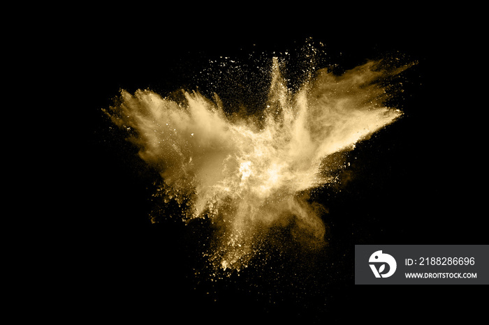 Golden powder explosion on black background. Freeze motion.