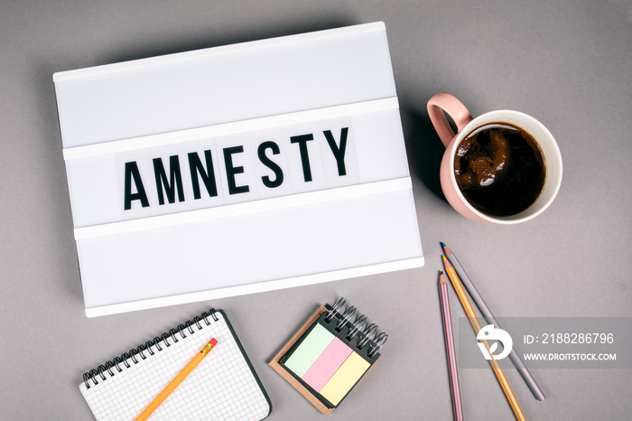 Amnesty. Text in light box. Pink coffee mug on gray background