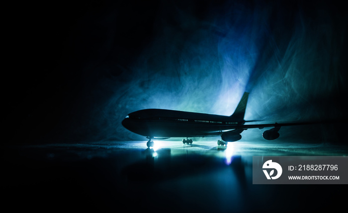 Artwork decoration. White passenger plane ready to taking off from airport runway. Silhouette of Aircraft during night time.