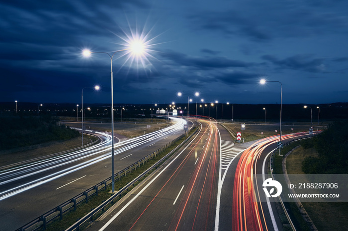 Light trails of cars. Traffic on illuminated highway at night..