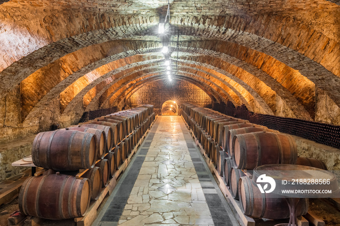 Old wooden barrels with wine in the ancient medieval cellars