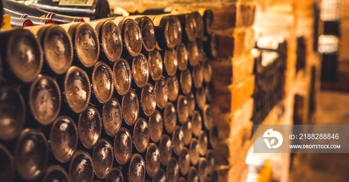 Old wine bottles dusting in an underground tratitional cellar... Small and old wine cellar with full wine bottles. Winery concept.