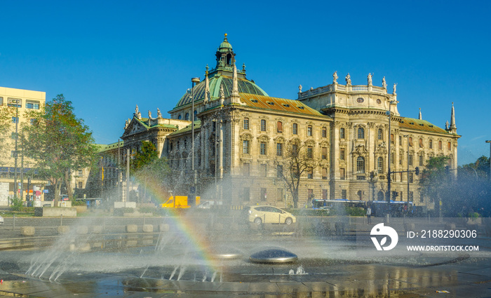 View of langericht court in german city munich hidden behind magnificent fountain.