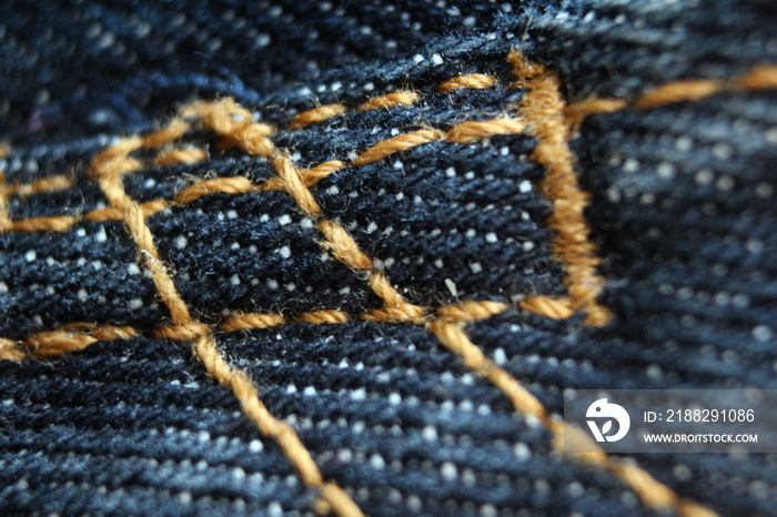 Macro detail of classic blue jeans fabric and sewing