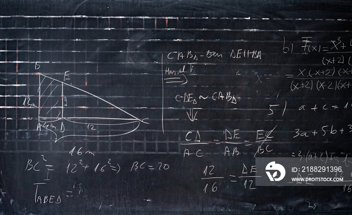 Maths formulas written by white chalk on the blackboard background.