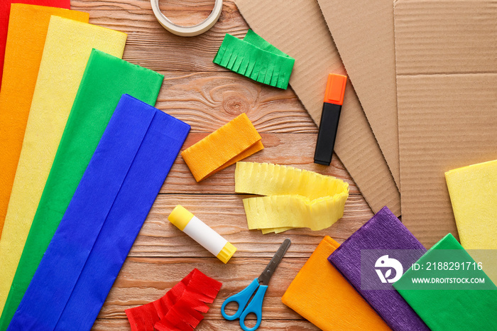 Materials for making colorful Mexican pinata on wooden background