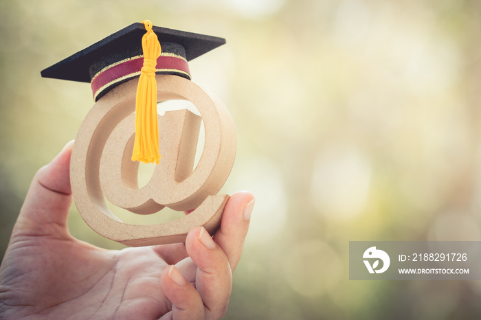 Online Learning in study abroad university education concept: Graduation cap on email address symbol in student hands. Ideas communication international school, can learn course by internet technology