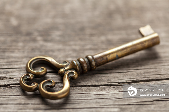 Old copper key on wooden table