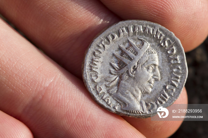 Hand holding Roman denarius (Roman silver coin)