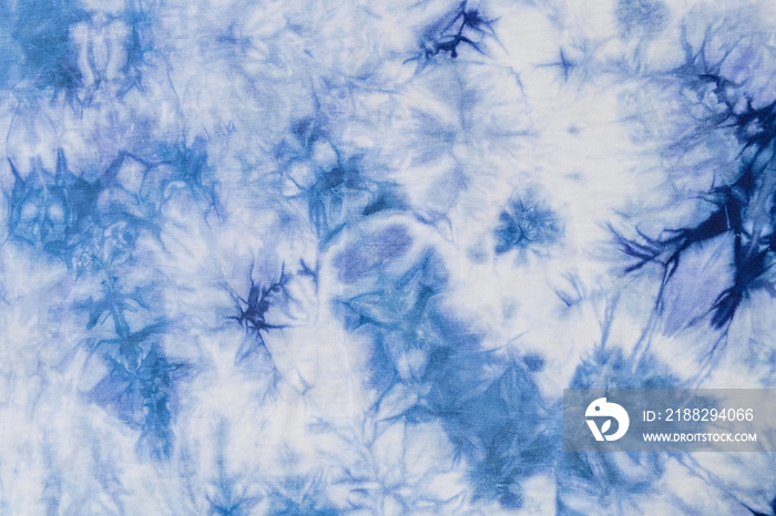 Close-up batik shirt with abstract indigo blue dye detail on white fabric cotton background on top-view