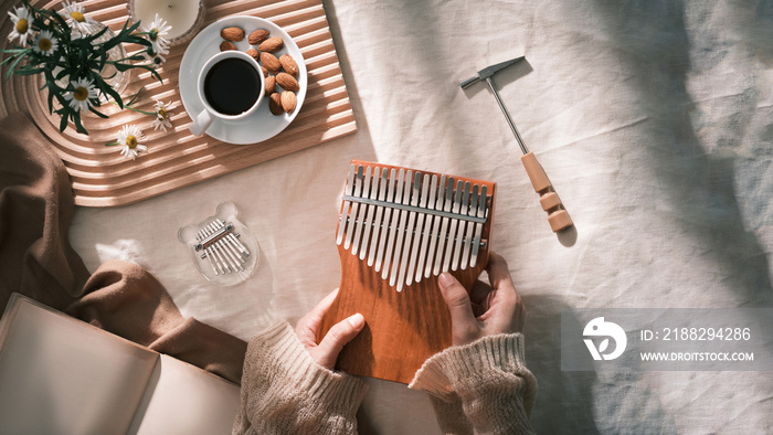 Topview girl playing Kalimba, acoustic music instrument from africa. Kalimba concept.