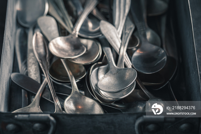 Closeup of stack of spoons in a metal box