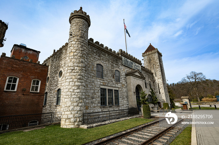 Main building of bourbon distillery in Kentucky designed in a shape of a castle with old train tracks cut to make room for the entrance alley