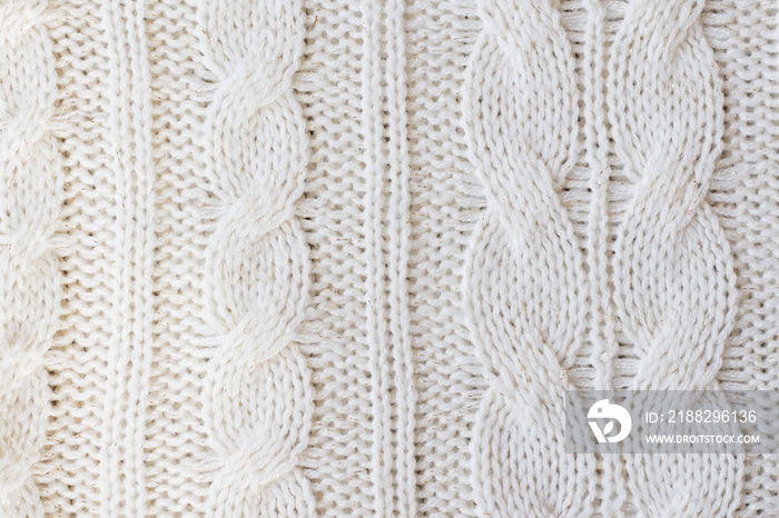 White knitted carpet closeup. Textile texture off white background. Detailed warm yarn background. Knit cashmere beige wool. Natural woolen fabric, sweater fragment.