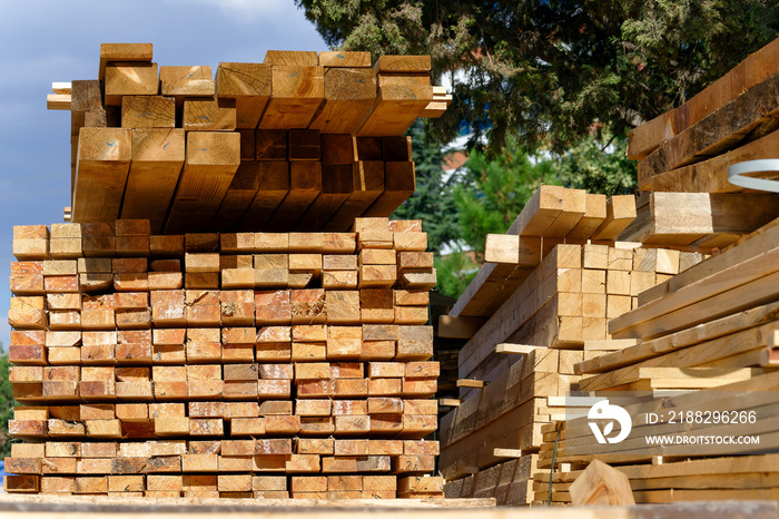 Blocks of pine sawn timber for the construction of roof houses and cottages stacked on the lumberyards site, ready for sale